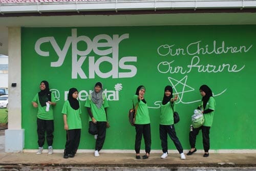 Cyberkids participants posed at the school&rsquo;s computer lab wall which has been painted with Cyberkids logo